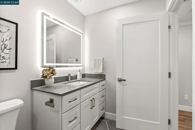 a bathroom with a granite countertop sink and a mirror