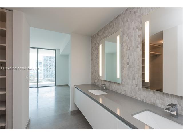 68 Southeast 6th Street, Unit 3708 Miami, FL 33131 - Photo 5 of 17 a bathroom with a sink and a mirror