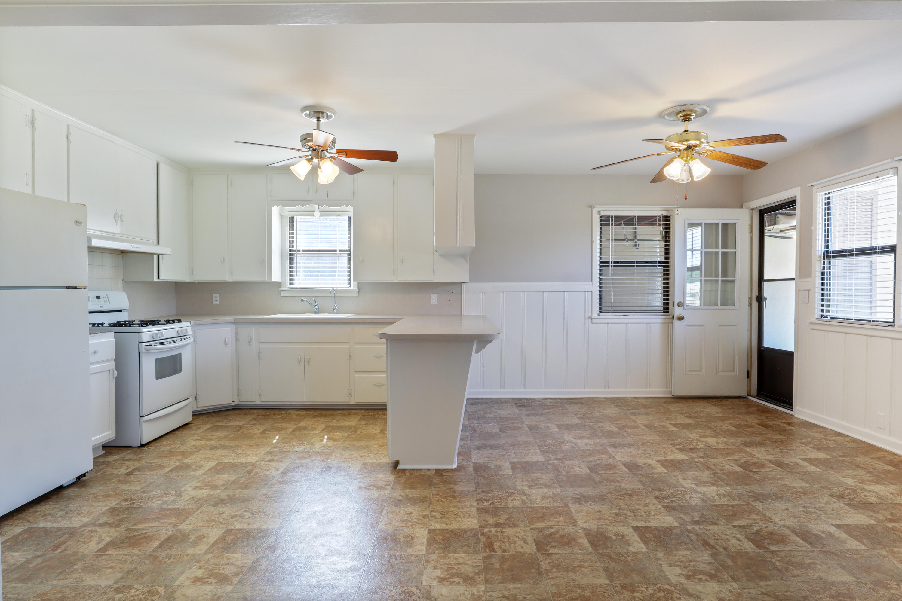 511 6th Street Wolfforth, TX 79382 - Photo 6 of 26 a kitchen with white cabinets and chandelier
