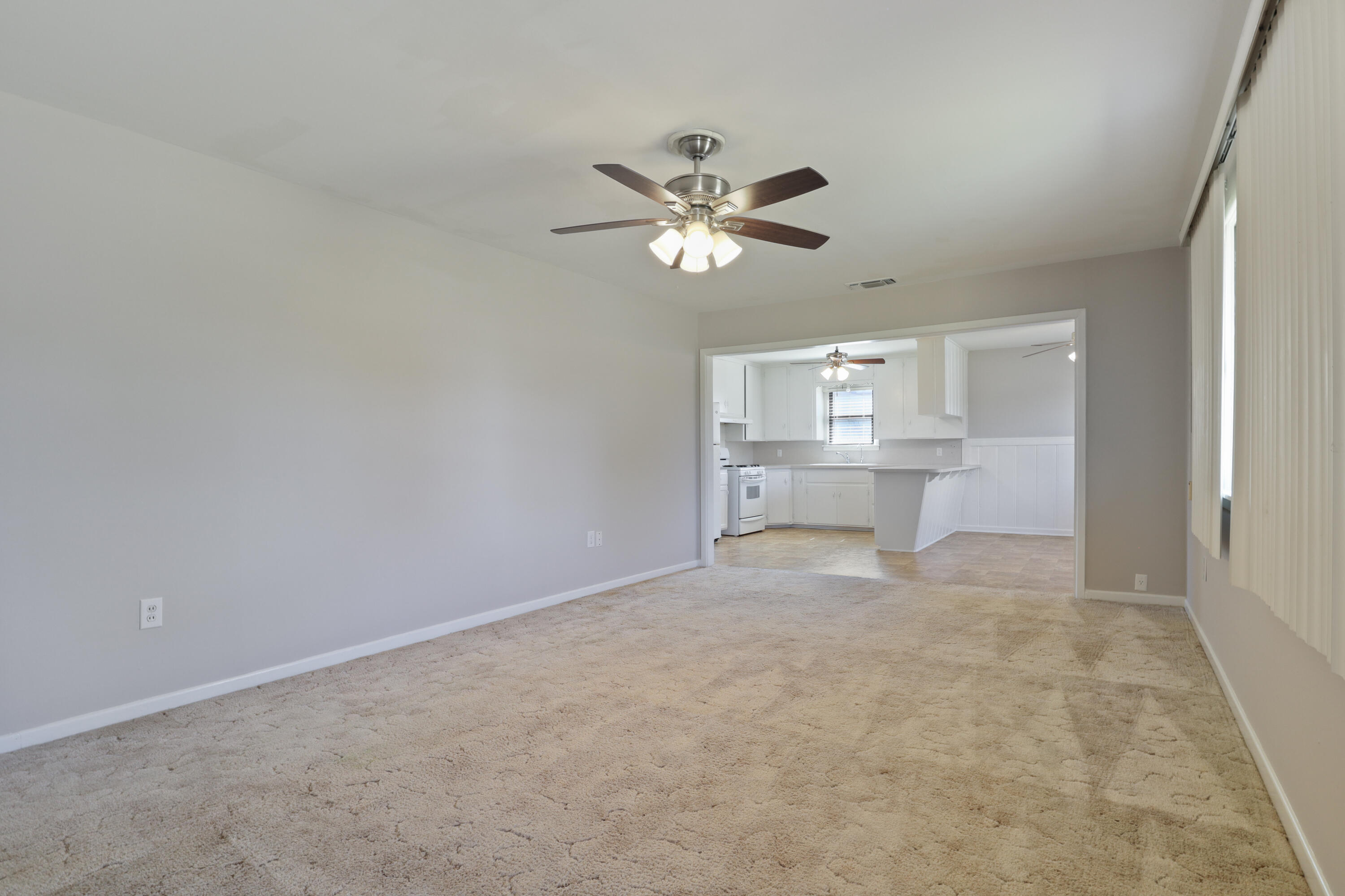 511 6th Street Wolfforth, TX 79382 - Photo 10 of 26 a view of a livingroom with a ceiling fan & kitchen space