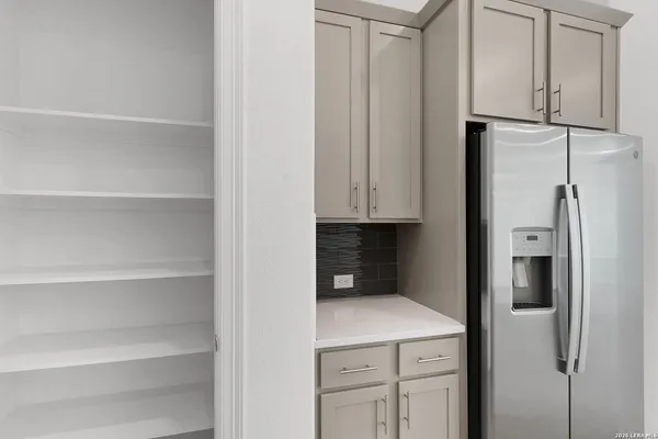 a kitchen with cabinets and a refrigerator