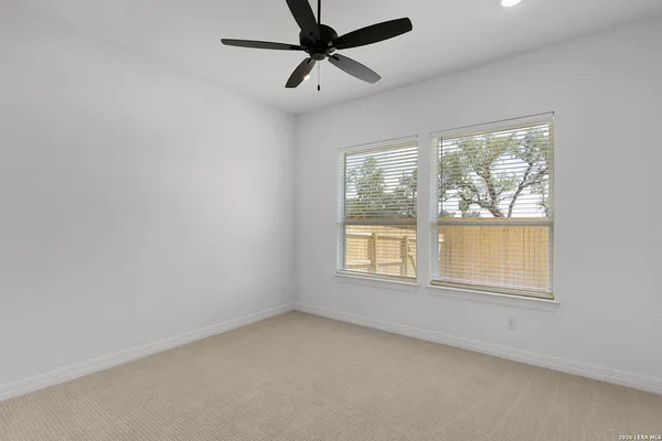 an empty room with a window and a fan