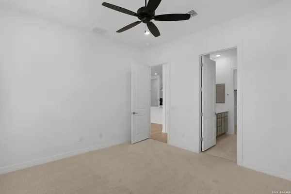 an empty room with closet and a ceiling fan