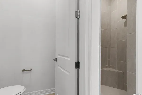 a white toilet sitting next to a shower