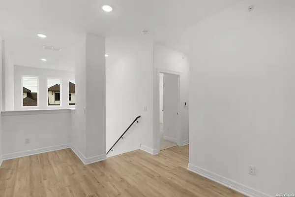 a view of a hallway with wooden floor