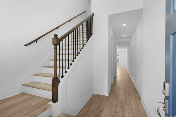 a view of staircase with wooden floor and white walls
