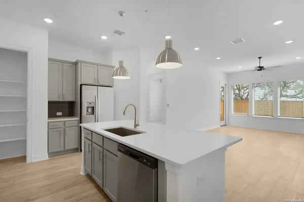 a kitchen that has a sink a stove and a refrigerator