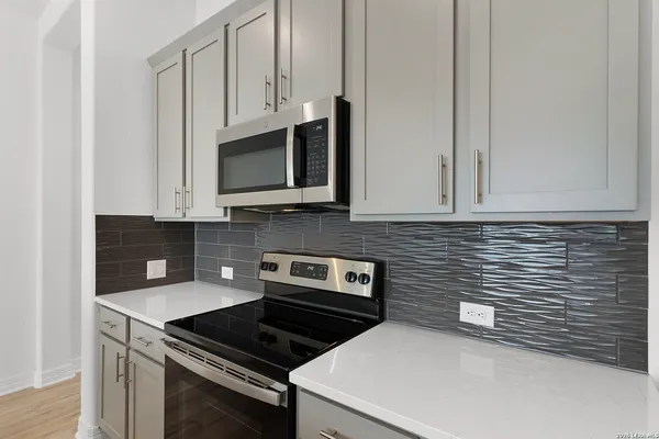 a kitchen with granite countertop white cabinets stainless steel appliances and a sink