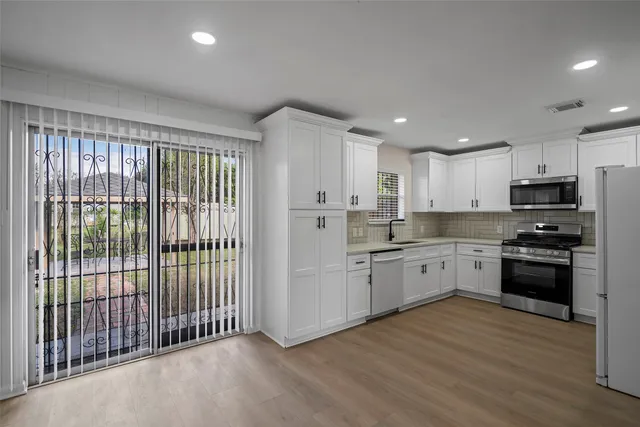 a kitchen with stainless steel appliances granite countertop a refrigerator and a stove top oven