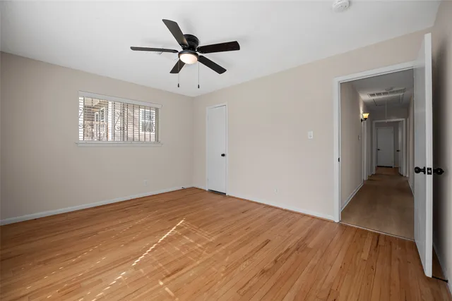 a view of a big room with wooden floor and windows