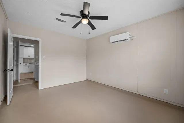 an empty room with a ceiling fan and window
