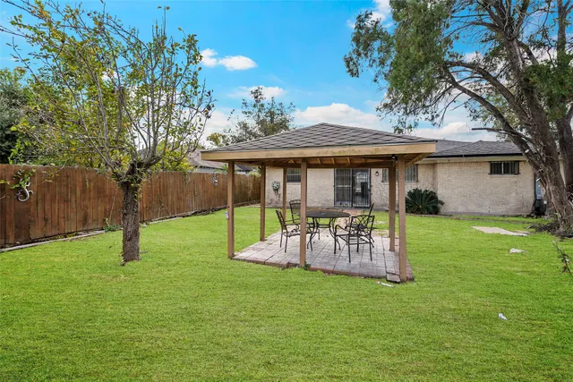 a view of a chair and table in backyard of the house