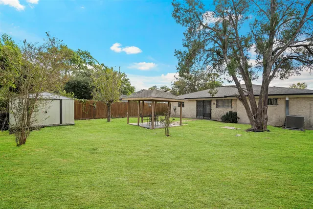 a backyard of a house with table and sofas