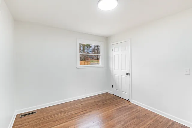a view of an empty room with wooden floor