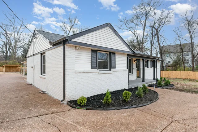 a front view of a house with a yard and potted plants
