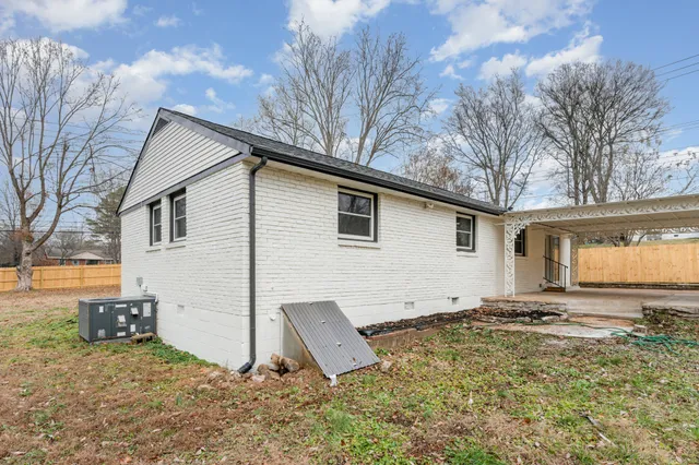 a view of a house with backyard and trees