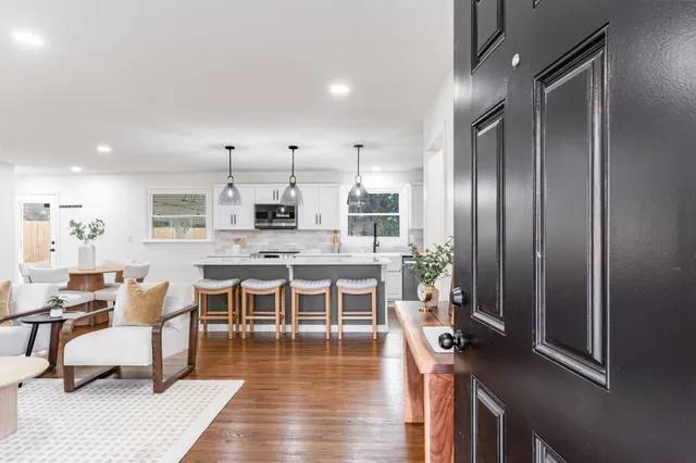 a large kitchen with a table chairs refrigerator and cabinets