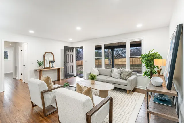 a living room with furniture potted plant and a large window