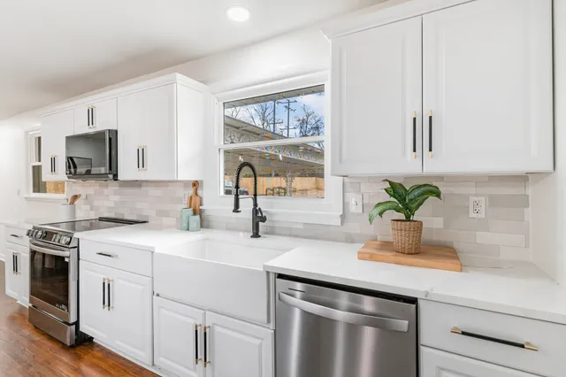 a kitchen with appliances a sink and cabinets