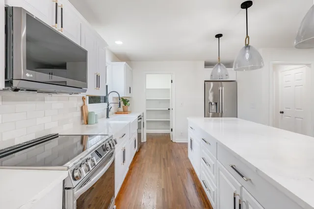 a kitchen with a sink a counter top space stainless steel appliances and a counter top space