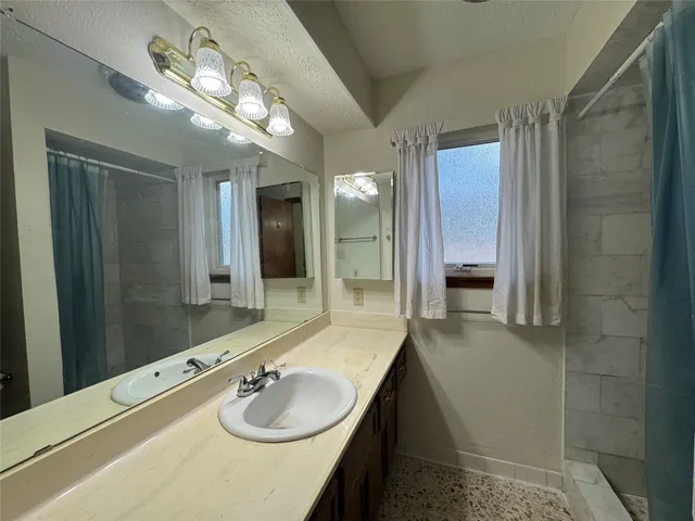 a bathroom with a sink a shower and a mirror