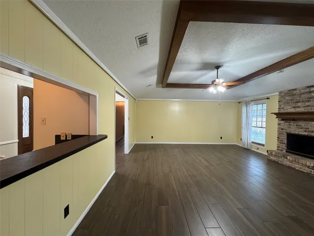 a view of a living room with wooden floor and a fireplace