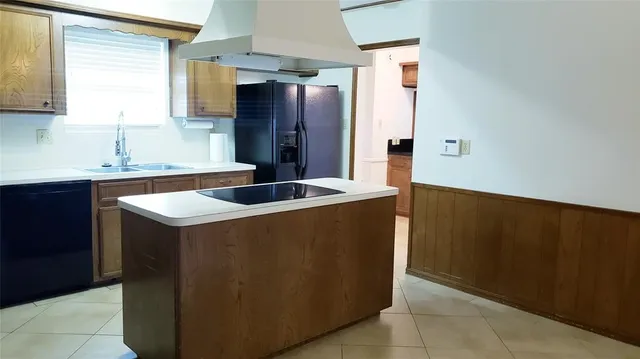 a kitchen with a sink a refrigerator and cabinets