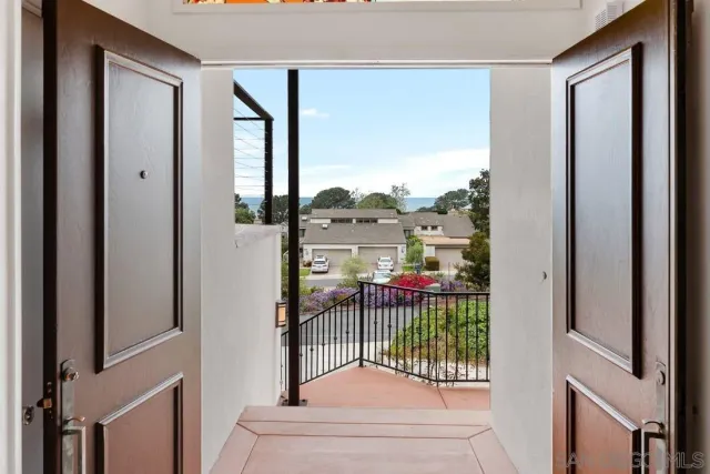 a view of an empty room with wooden floor and a fireplace