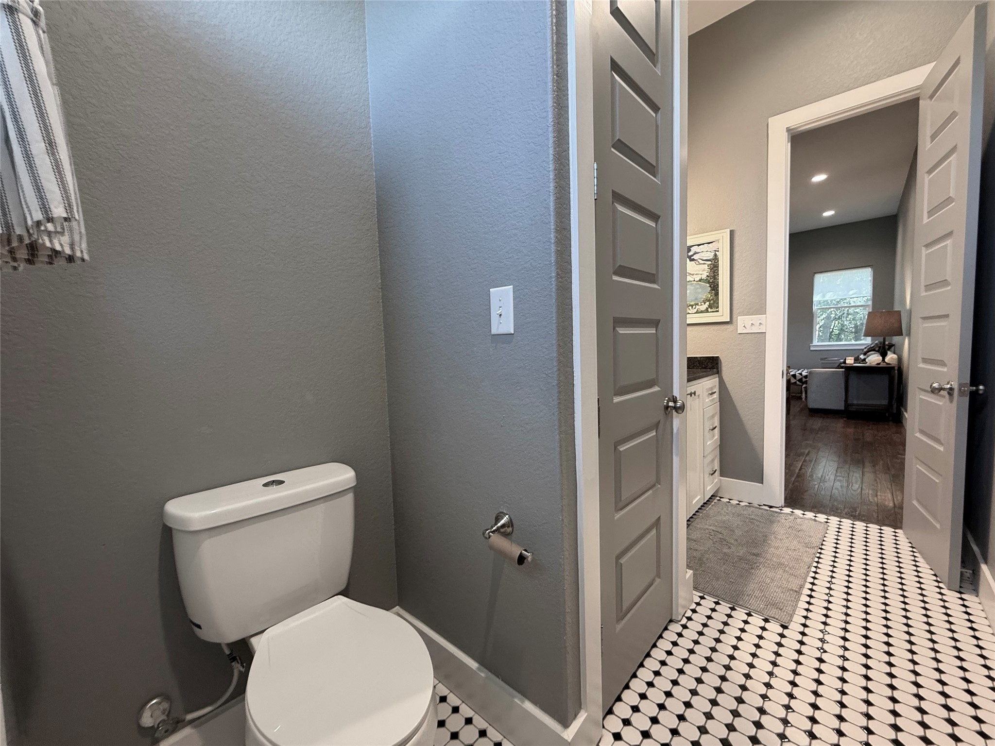739 Pleasant Grove Road Elgin, TX 78621 - Photo 17 of 29 White two-piece toilet in a powder room featuring gray walls and black and white penny tile flooring