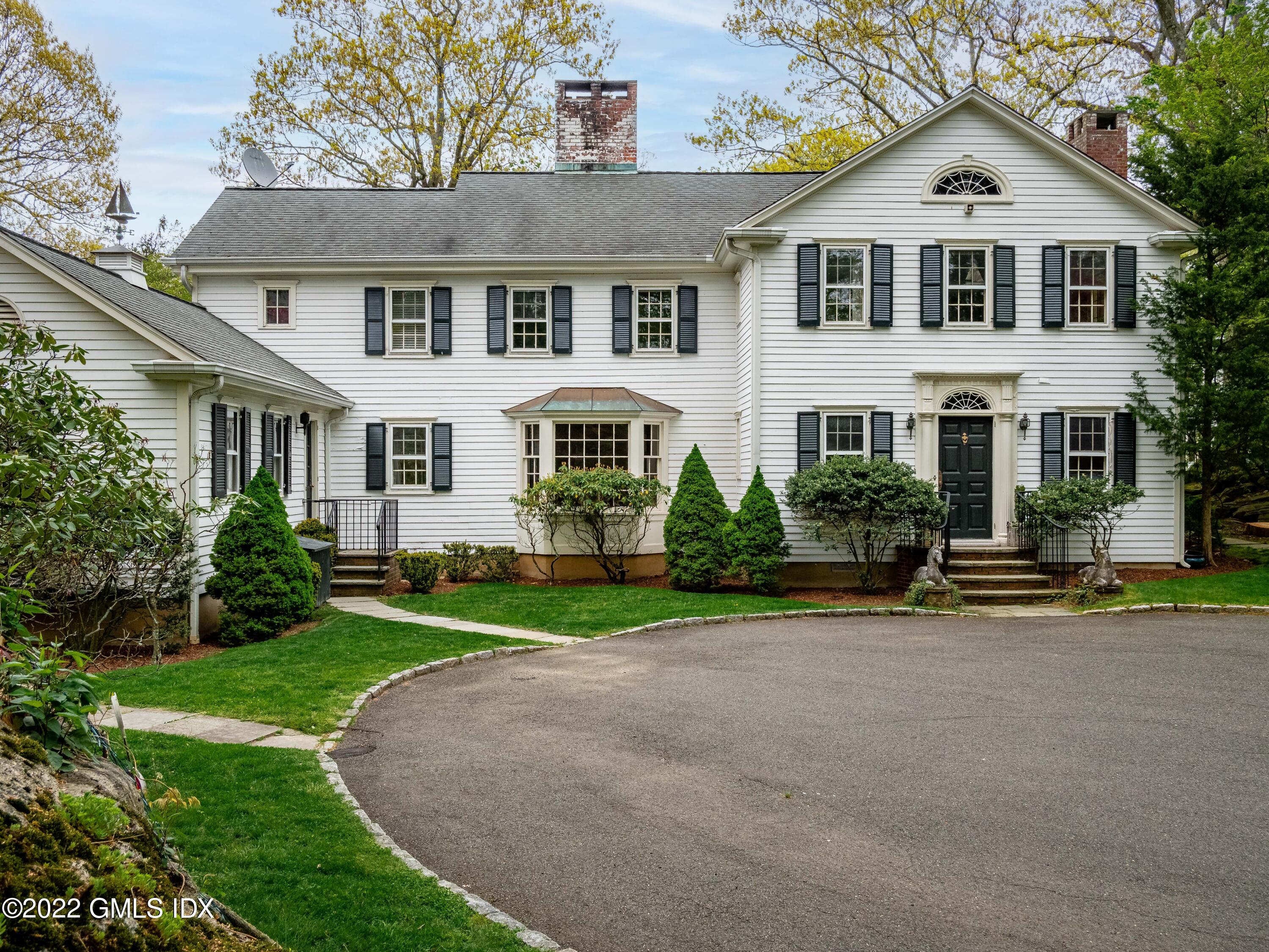 Great Island Darien, CT 06820 - Photo 11 of 16 a front view of a house with a yard and trees