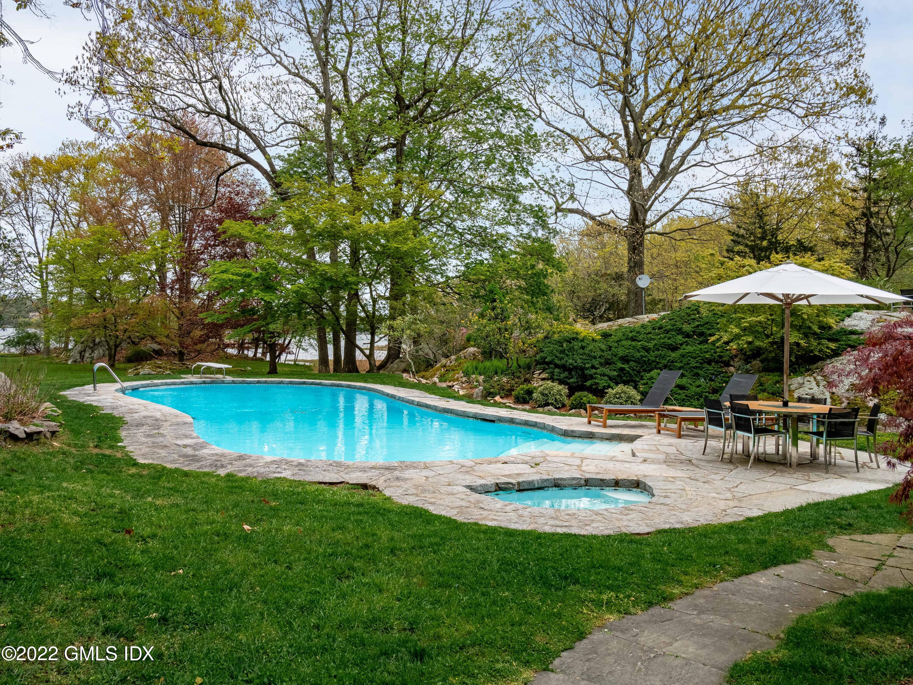 Great Island Darien, CT 06820 - Photo 12 of 16 a view of a swimming pool with lawn chairs under an umbrella