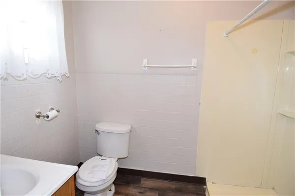 a white toilet sitting next to a white sink and vanity
