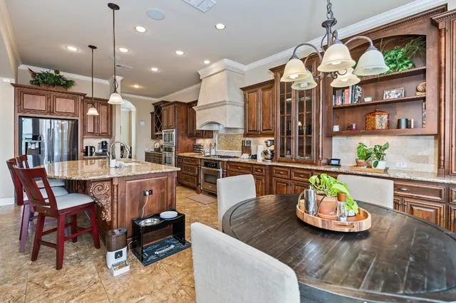a kitchen with a table chairs and wooden floor