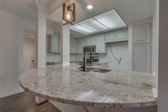 a view of a kitchen with a sink and wooden cabinets