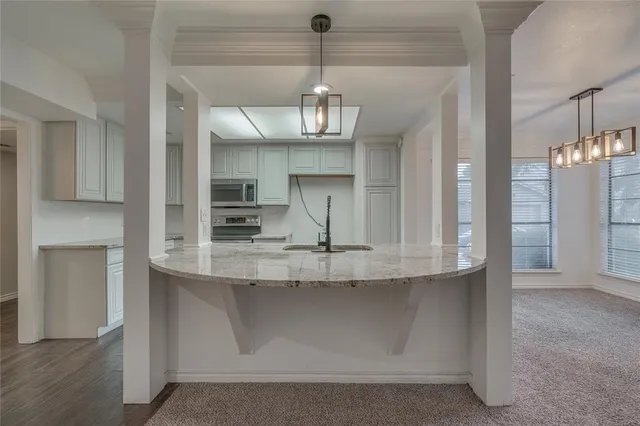a kitchen with kitchen island granite countertop a stove and a refrigerator