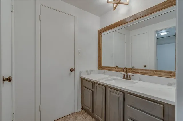 a bathroom with a granite countertop toilet a sink and shower