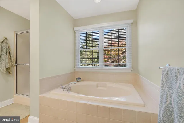 a spacious bathroom with a double vanity sink a mirror and a bathtub