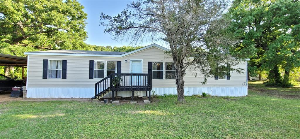 a backyard of a house with table and sofas