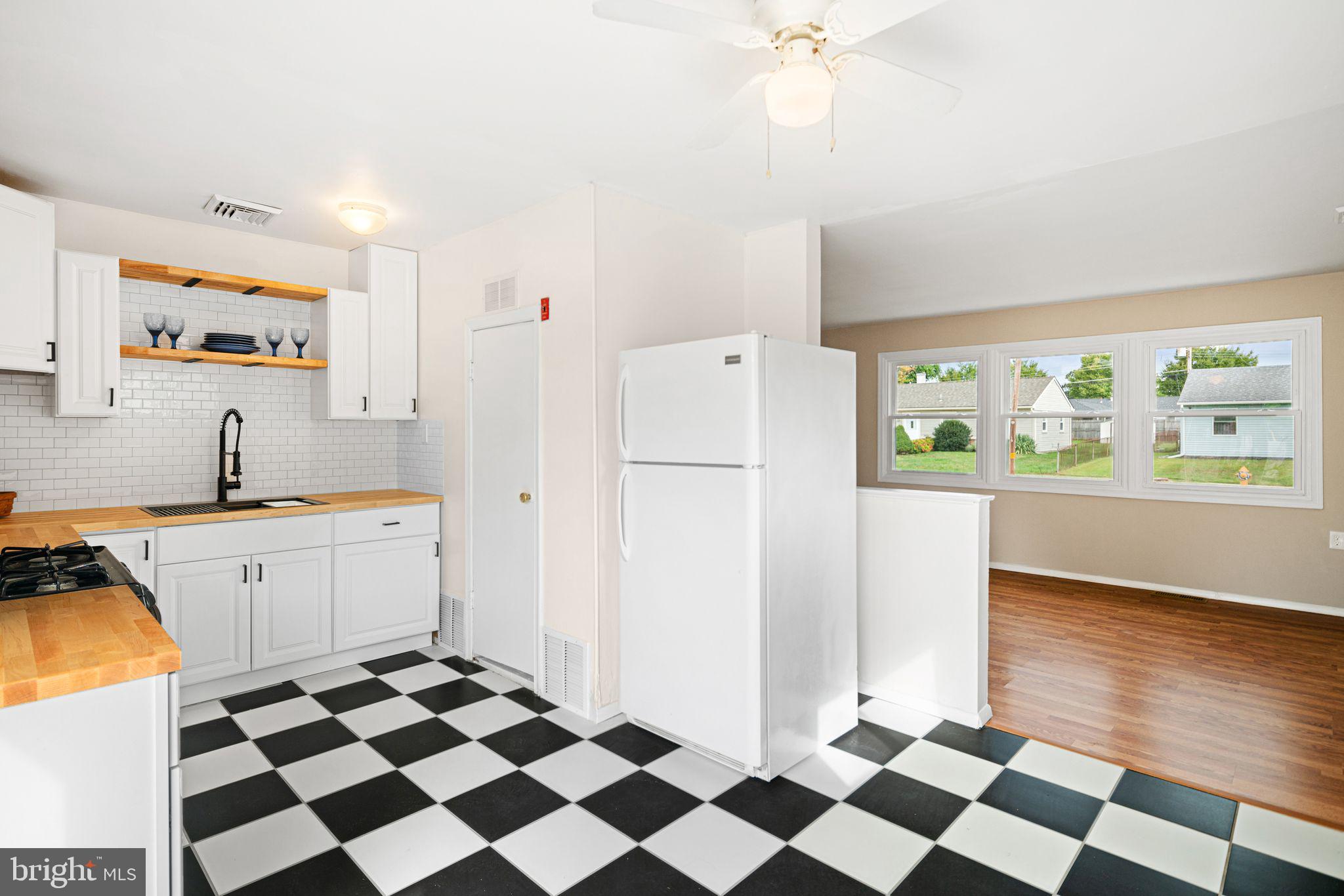 906 Stephen Avenue Croydon, PA 19021 - Photo 7 of 20 a kitchen with a checkered floor and a refrigerator