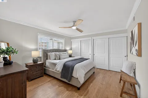 a spacious bedroom with a bed and a potted plant on the dresser