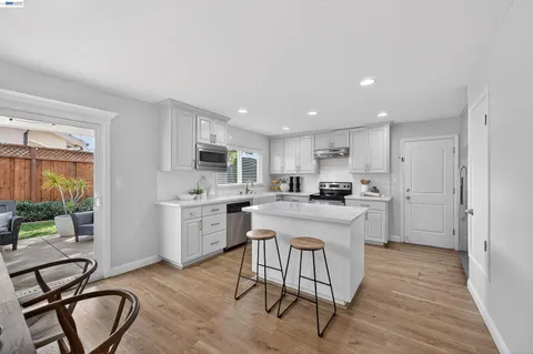 a kitchen with white cabinets and sink