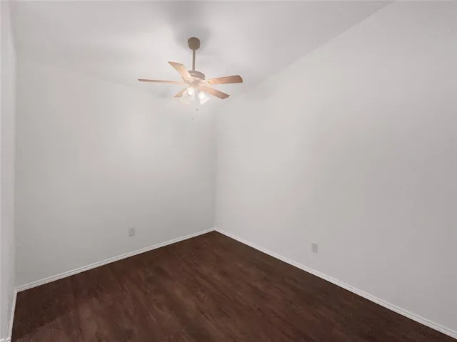 an empty room with a window and ceiling fan