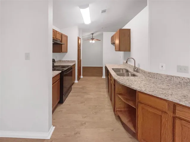 a kitchen with granite countertop a sink and a stove