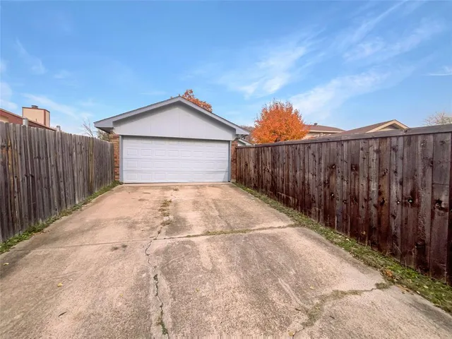 a view of backyard of house with wooden fence