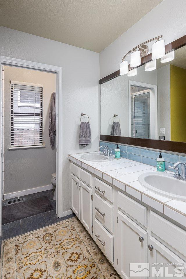 5346 Mountcrest Lane Reno, NV 89523 - Photo 12 of 32 a spacious bathroom with a double vanity sink and a mirror