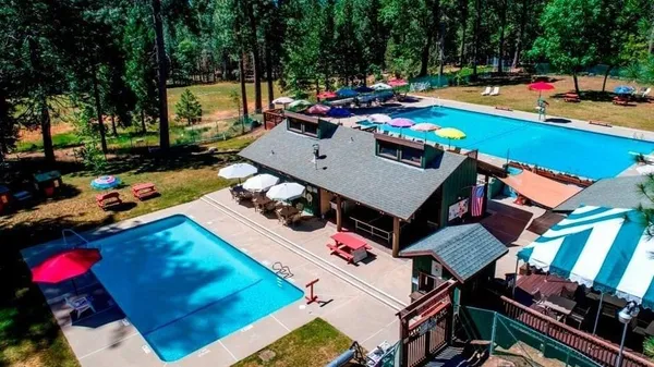 an aerial view of a house with swimming pool and outdoor seating