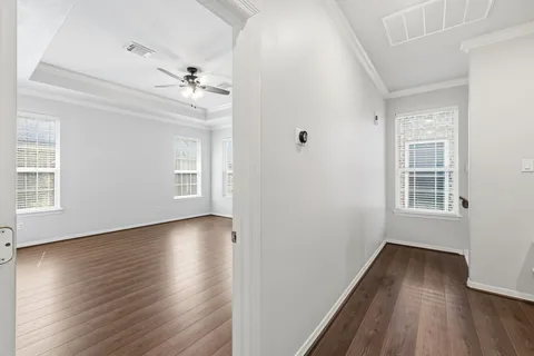 an empty room with wooden floor and windows