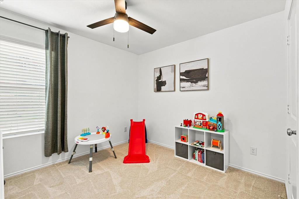 11741 Marcellus Way Rhome, TX 76078 - Photo 25 of 34 Neutral wall paint, ceiling fan with integrated lighting, window with blinds, and carpeted flooring