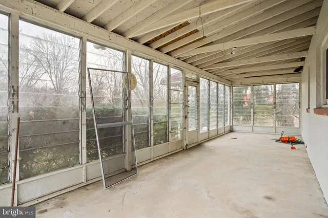 a view of empty room with wooden floor and door