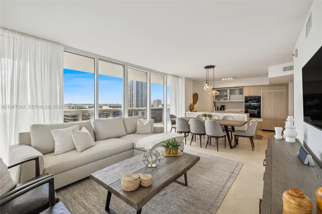 a living room with furniture kitchen view and a large window